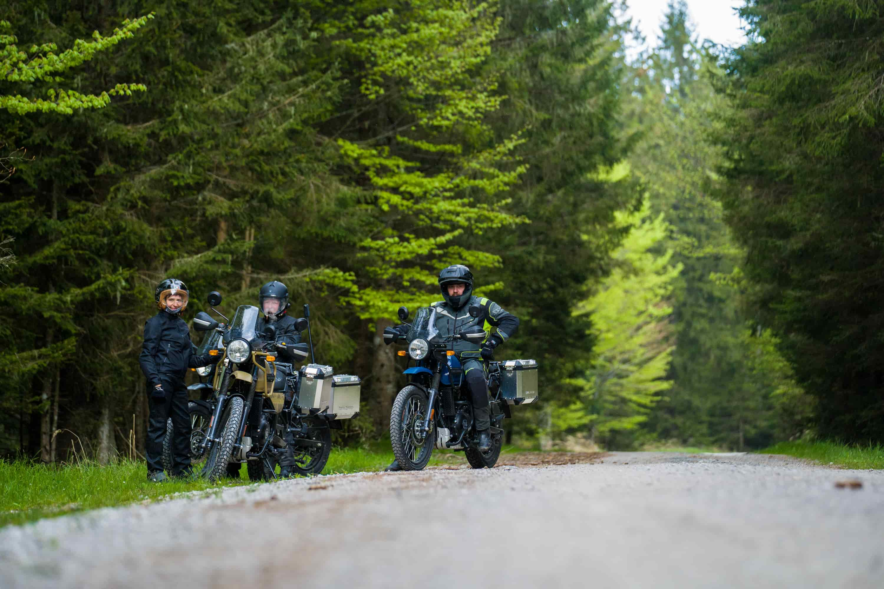 3 people at the side of the road on royal enfield motorcycles